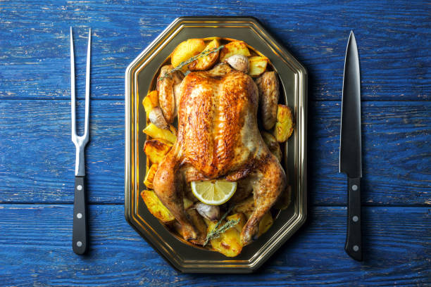 istock Lemon and thyme roasted chicken with carving fork and knife 1184722246