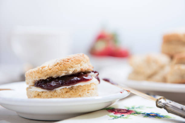 Traditional homemade british scones with butter and strawberry jam on white wooden table. Horizontal. Copy space.