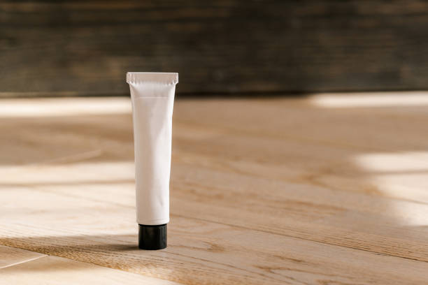 tubo branco cosmético na tabela de madeira - human skin sparse washing face human face - fotografias e filmes do acervo