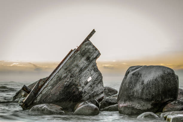 Shipwreck Beached On The Rocky Coast Of Lake Huron In Michigan Wooden shipwreck beached on the rocks of Lake Huron on the coast of Lake Huron in Lexington, Michigan. ghost ship stock pictures, royalty-free photos & images