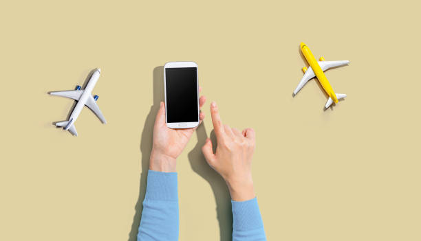 istock Person holding a smart phone with airplanes 1184747448