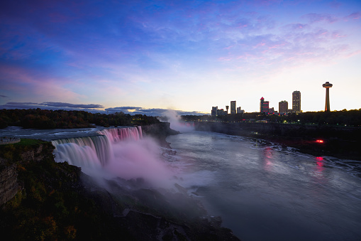 Niagara falls lit at night by colorful lights