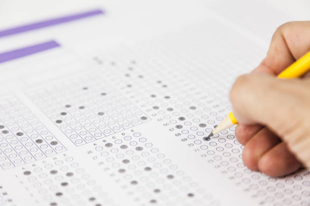 istock students hand doing exams quiz test paper at school 1184767044