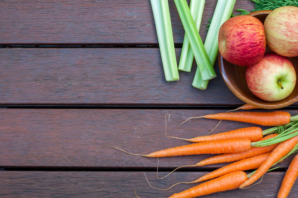 istock Carrots, apples and celery on the wood 1184768256
