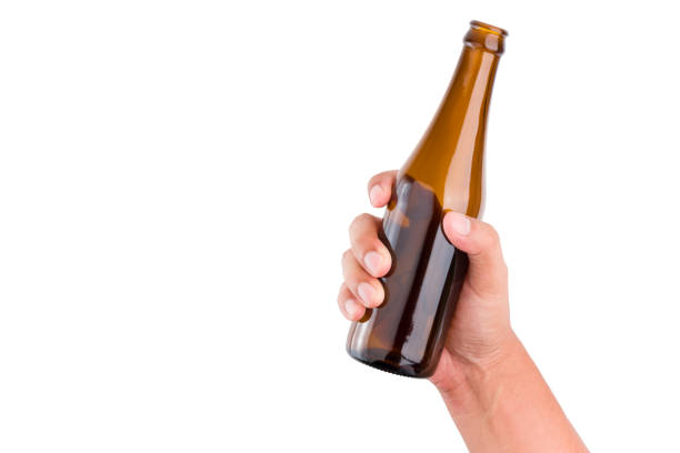 mano umana che tiene la bottiglia marrone su sfondo bianco isolato con percorso di ritaglio. - bottiglia di birra foto e immagini stock