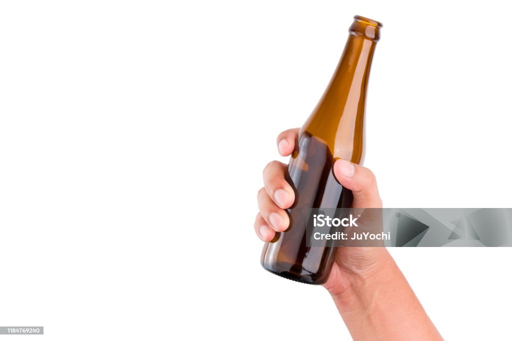 Human hand holding brown bottle on isolated white background with clipping path. Hand Stock Photo