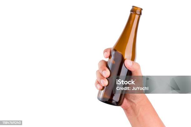 Human Hand Holding Brown Bottle On Isolated White Background With Clipping Path Stock Photo - Download Image Now
