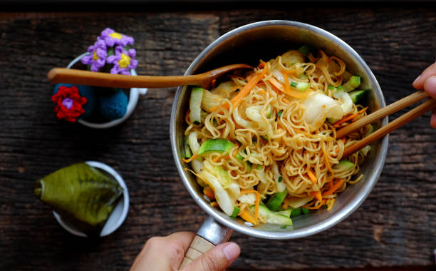 human hand mix  instant noodles with vegetables for quick vegan breakfast
