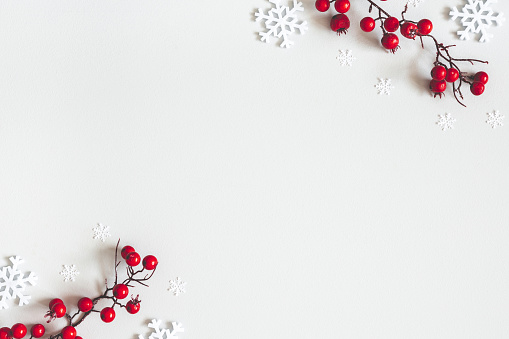 Composición de Navidad o invierno. Copos de nieve y bayas rojas sobre fondo gris. Navidad, invierno, concepto de Año Nuevo. Plano, vista superior, espacio de copia photo