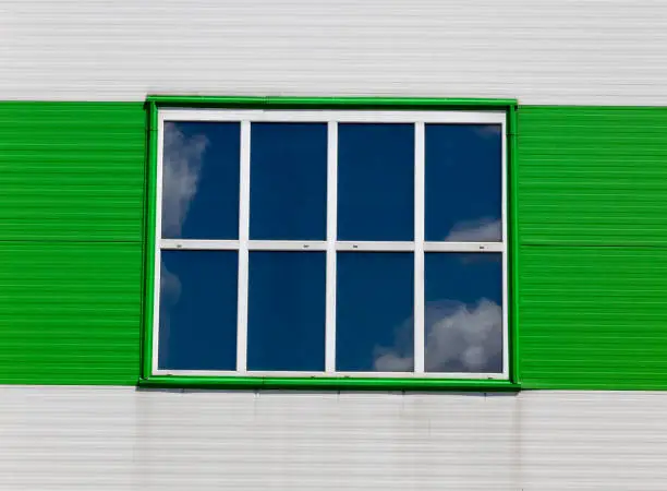 modern metal building, which is used as a warehouse and office for other purposes, painting in green and white