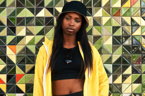 I am powerful and confident Cropped portrait of an attractive young woman standing alone against a brightly tiled wall during the day crop top view stock pictures, royalty-free photos & images