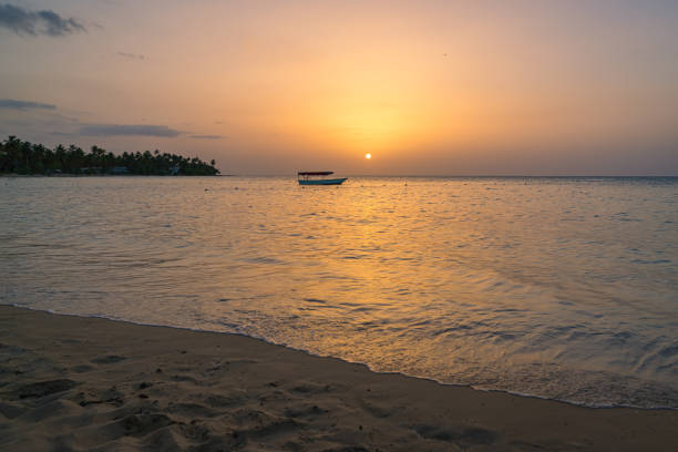 fishing boat resting in the sand in Praia do Forte Beach at sundown
