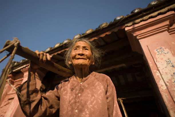 Hoi an, Quang Nam Province, Vietnam -  February 24, 2011: Senior Vietnamese woman sells fruits for tourists in the historic center of Hoi An,  a french colonial city on Vietnam’s central coast