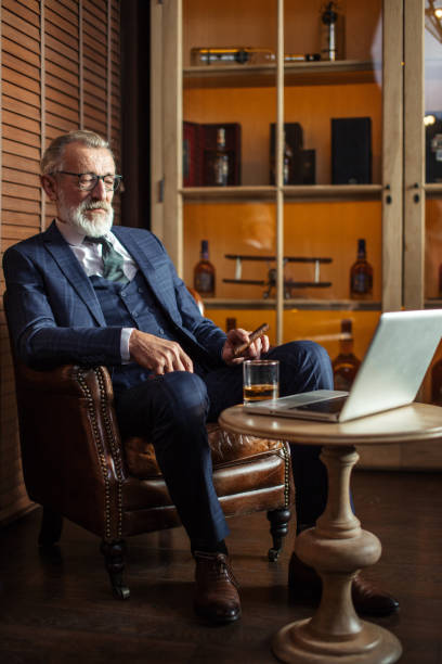 istock Senior dramatist looking at laptop, creating novel while sitting 1184795158