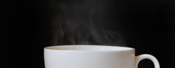 istock hot steam from the white cup with coffee drink on the dark background 1184804593