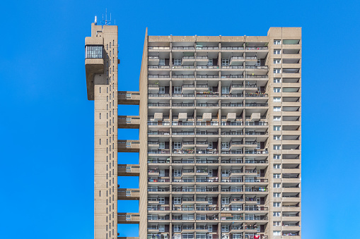 A Brutalist style tower block, Trellick Tower, in London against a cloudless sky