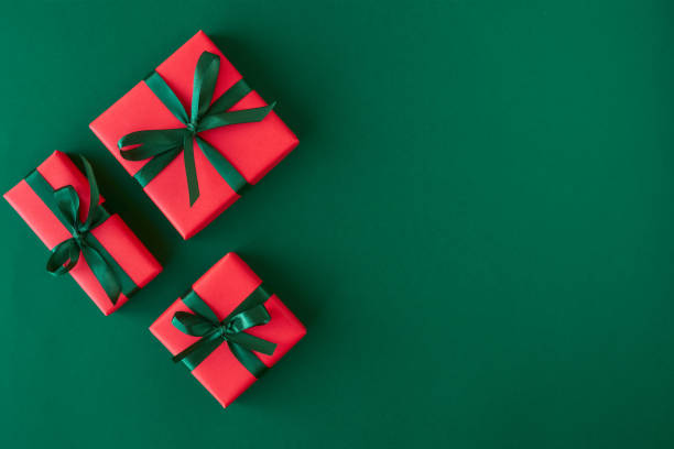 istock Red gift boxes on green background. Christmas card. Flat lay. Top view with space for text 1184807226