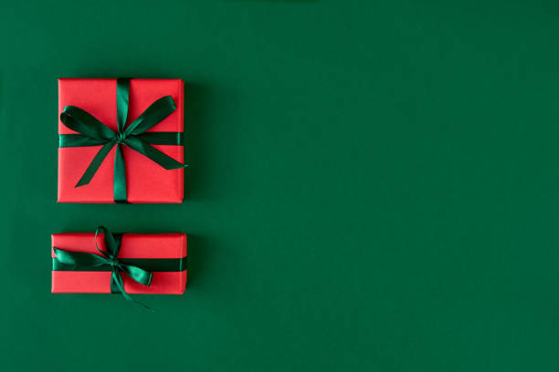 istock Red gift boxes on green background. Christmas card. Flat lay. Top view with space for text 1184807257