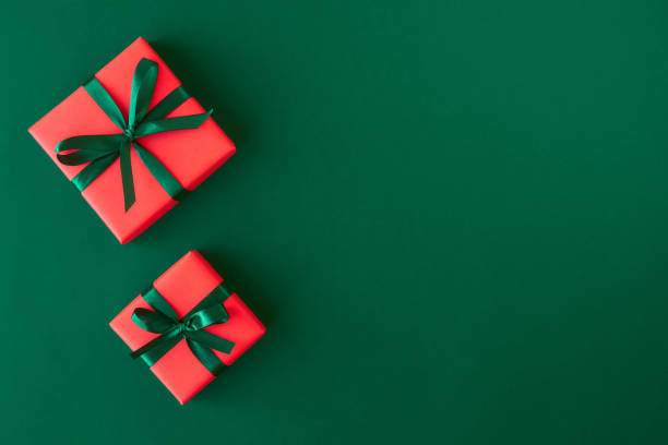 istock Red gift boxes on green background. Christmas card. Flat lay. Top view with space for text 1184807276