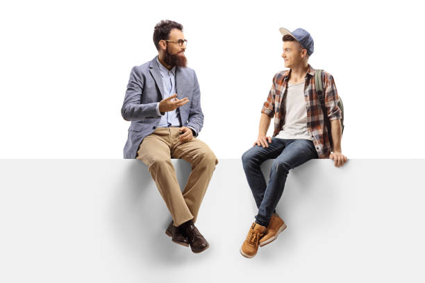 istock Teacher talking to a male student sitting on a panel 1184809689
