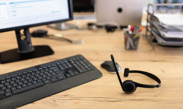 dispositivo do fone de ouvido do call center na mesa do escritório para o conceito do telemarketing da linha direta - setup operator - fotografias e filmes do acervo