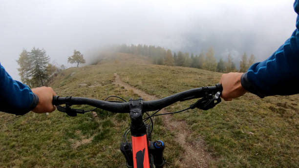 istock Young man on mountain bike rides down grassy field 1184811144
