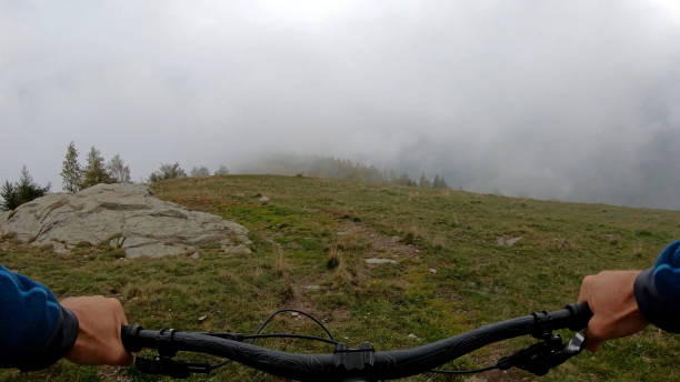 istock Young man on mountain bike rides down grassy field 1184811218