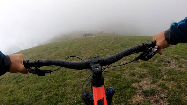 istock Young man on mountain bike rides down grassy field 1184811276