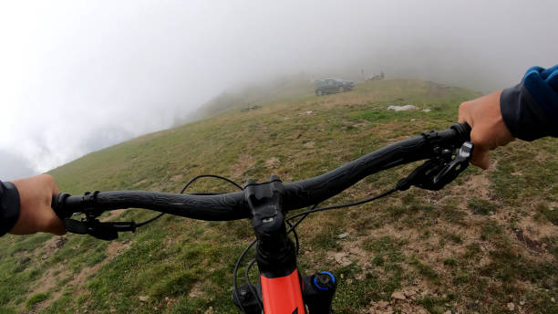 istock Young man on mountain bike rides down grassy field 1184811290