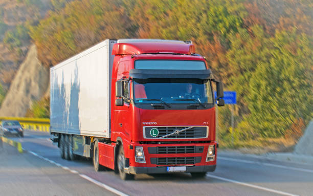 The truck has a red cab and is in motion.Pannig effect. A beautiful autumn landscape. Location: Orsova, Romania. October, 20, 2019.