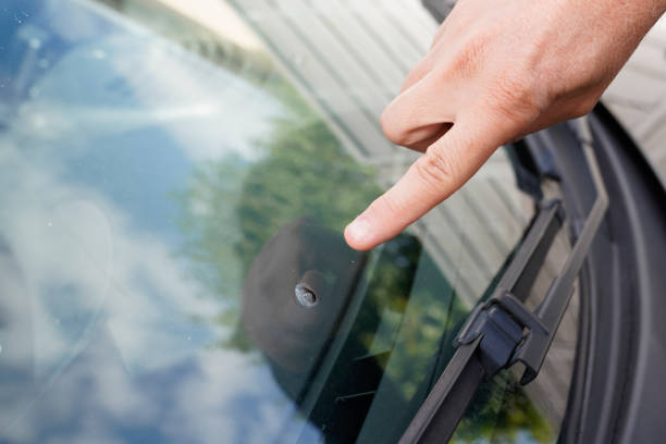 parabrisas de glazier en vidrio del parabrisas del coche roto de piedra señaló reloj de la mano del dedo - smashed potatoes fotografías e imágenes de stock