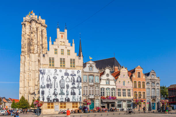 Tourists and local people strolling in the Grote Markt, the main square of Mechlin. The square and the streets of the old town are bordered by beautiful ancient buildings.