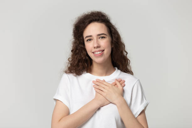 istock Sincere attractive young smiling girl feeling grateful. 1184817616