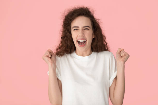 istock Overjoyed young lady clenching fists, celebrating success. 1184817658