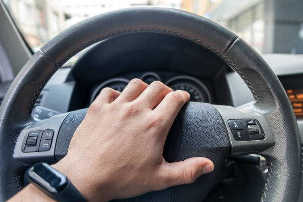 istock Drivers hand on a steering wheel of a car. 1184818215