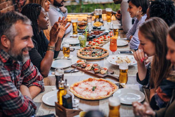 istock Group of friends sitting outdoors in restaurant 1184819643