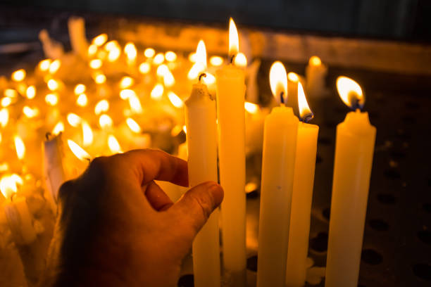 istock Hand lighting a candle in the church 1184819720