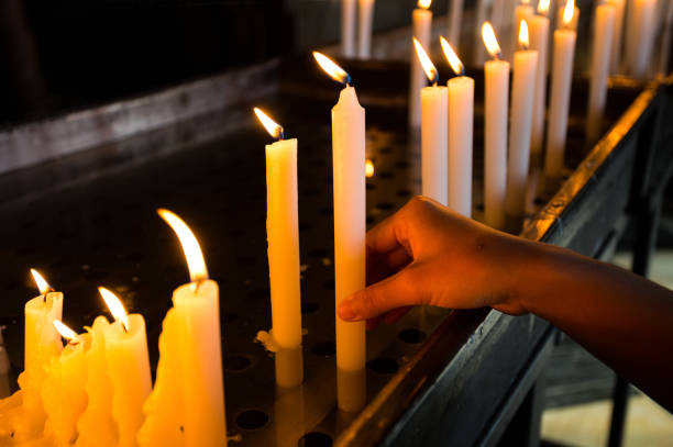 istock Hand lighting a candle in the church 1184819738