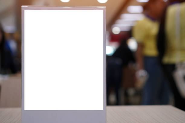 istock Blank mock up or label menu frame advertising in restaurant, Stand for booklets white paper sheets acrylic tent card on wood table in cafeteria, blurred background layout insert text for customer 1184820537