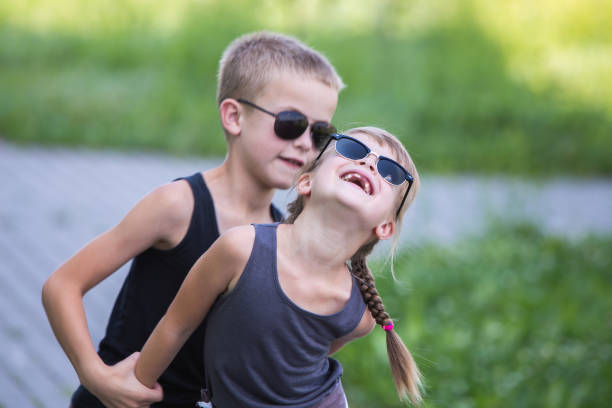 istock Two children in black sunglasses having fun time outdoors in summer. 1184825144