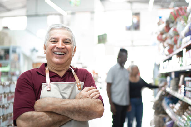 porträt eines lächelnden senior-arbeiters im großhandel - spanish and portuguese ethnicity horizontal looking at camera indoors stock-fotos und bilder