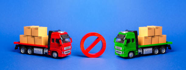 istock Prohibition sign NO between two trucks. Embargo trade wars. Restriction on importation, ban transit export dual-use goods to countries under sanctions. transport companies. 1184828015