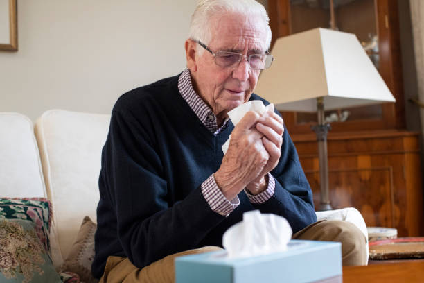 senior man at home suffering with cold or flu virus - tissue box flu virus kleenex imagens e fotografias de stock