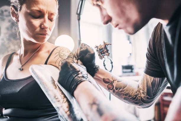 istock Artist Tattooing woman's shoulder 1184829243