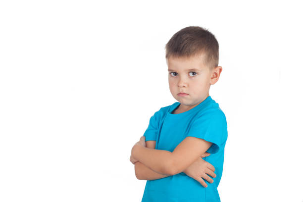 niño en edad preescolar de 5 años está enojado y ofendido, aislado sobre fondo blanco - furious blue little boys caucasian fotografías e imágenes de stock