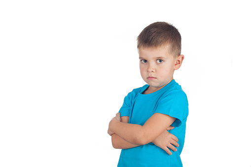 Preschool boy 5 years old is angry and offended, isolated on white background