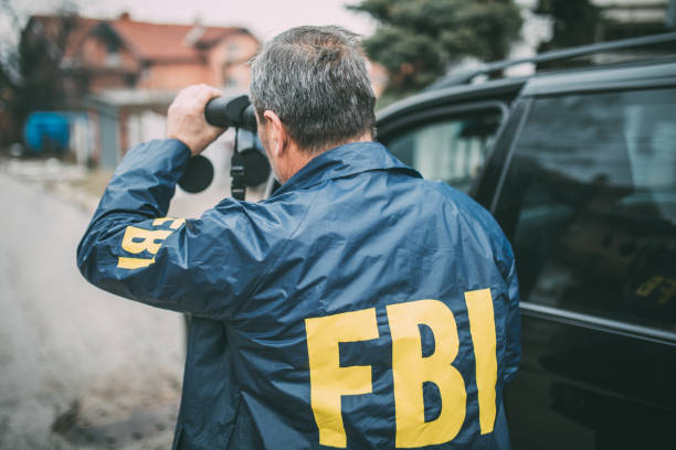 An old FBI agent uses binoculars An old FBI agent uses binoculars fbi photos stock pictures, royalty-free photos & images