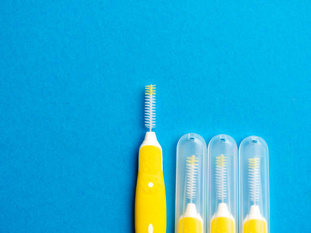 Interdental brush for interdental spaces over blue background with copy space. The concept of good mouth hygiene stock photo