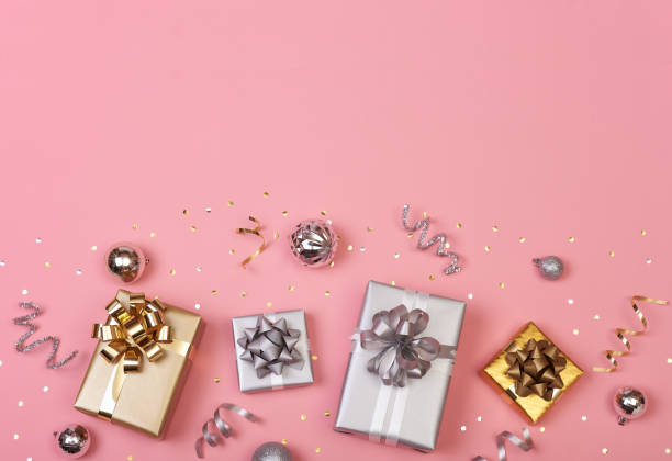istock Christmas composition with decorations and gift box with golden bows and star confetti on pink pastel background. winter, new year concept. Flat lay, top view, copy space. 1184832757
