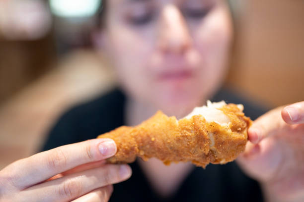 istock Young woman with fried chicken 1184835059